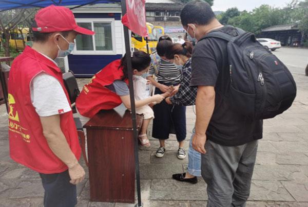 在剑门关景区北门游客中心,身着红色马甲的志愿者为游客提供旅游咨询